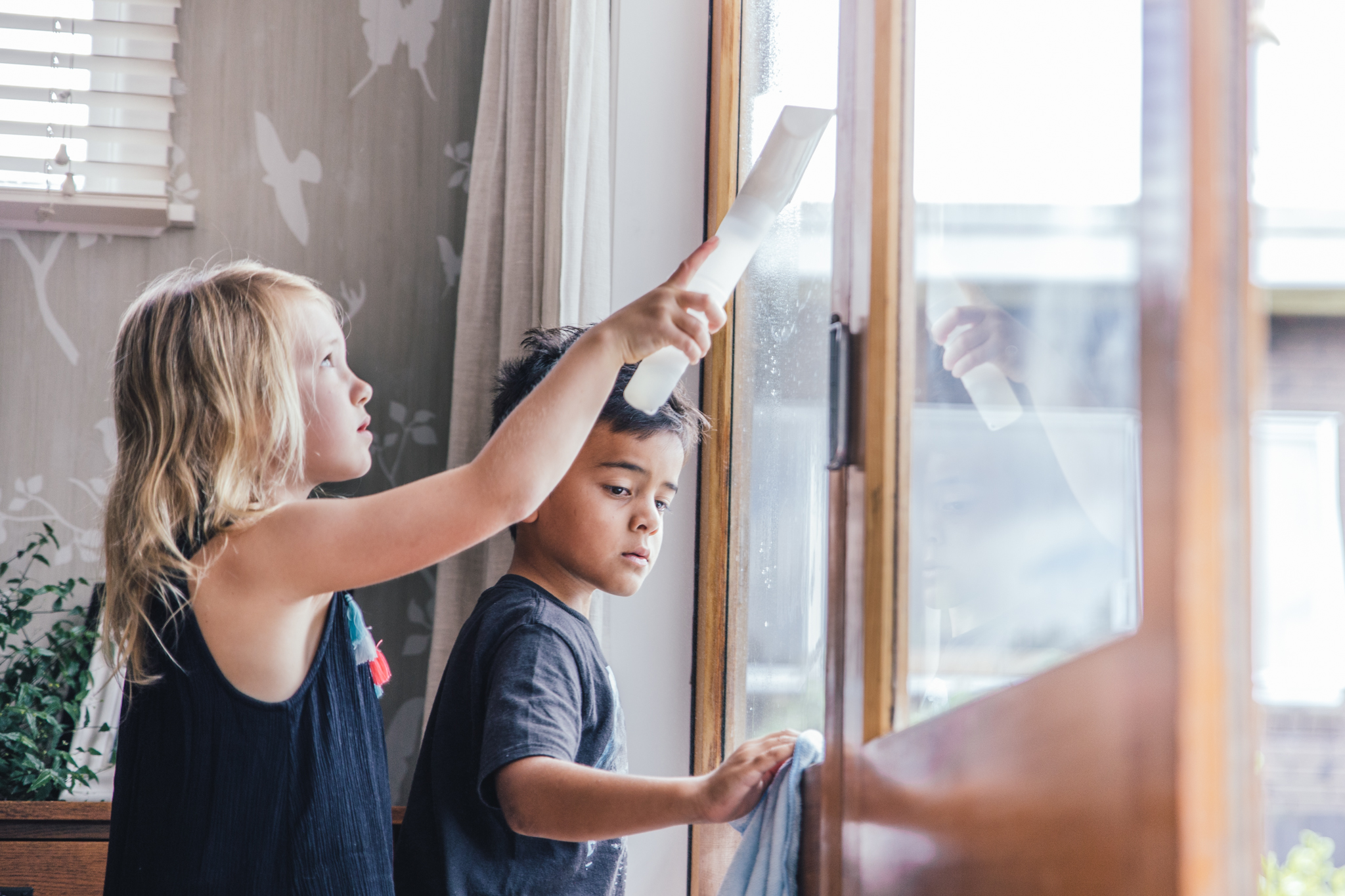 2 children wiping windows with a squeedgy